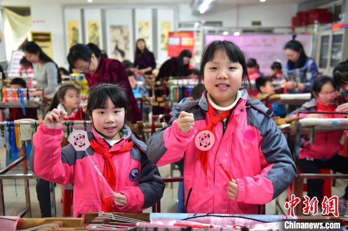 圖為小學(xué)生展示繡制好的2022年北京冬奧會(huì)吉祥物“冰墩墩”形象?！∮髟屏?攝