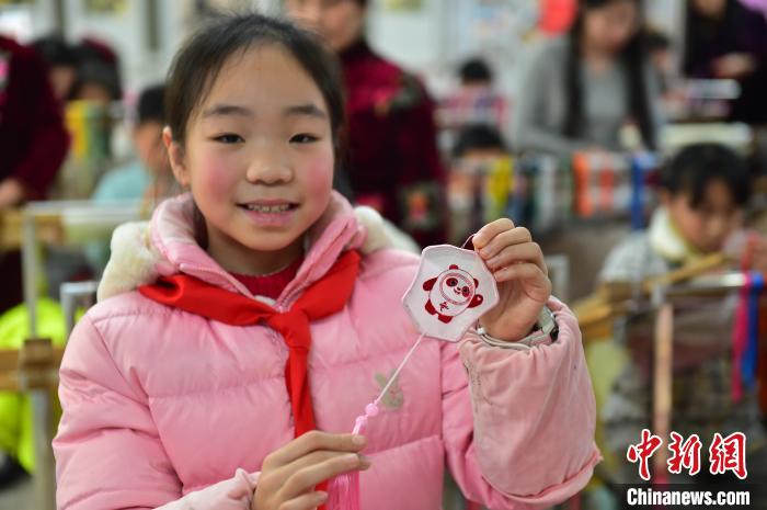 圖為一名小學(xué)生繡制的2022年北京冬奧會(huì)吉祥物“冰墩墩”形象?！∮髟屏?攝