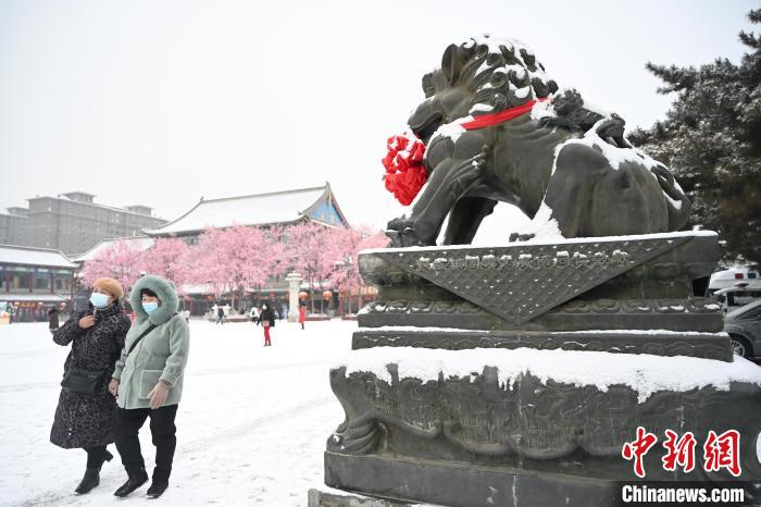 2月13日，民眾在呼和浩特市大召廣場雪中漫步?！⑽娜A 攝