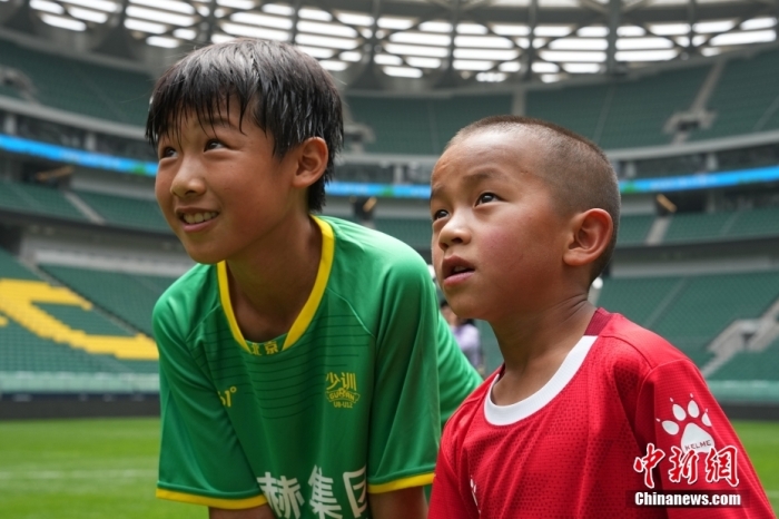 圖為北京國安小球員陳小北和7歲的俄金仁增在一起觀看場內(nèi)播放的紀(jì)錄片。<a target='_blank' href='/' _fcksavedurl='/'><p  align=