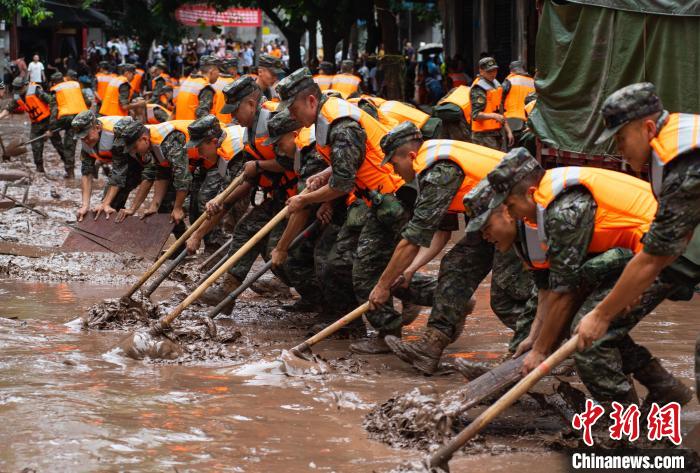 7月4日，萬州區(qū)五橋街道，武警官兵清理街道上的淤泥。　冉孟軍 攝