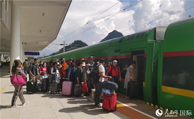 乘坐中老鐵路國際旅客列車的旅客在老撾瑯勃拉邦站排隊上車。人民網(wǎng)記者 杜明明攝