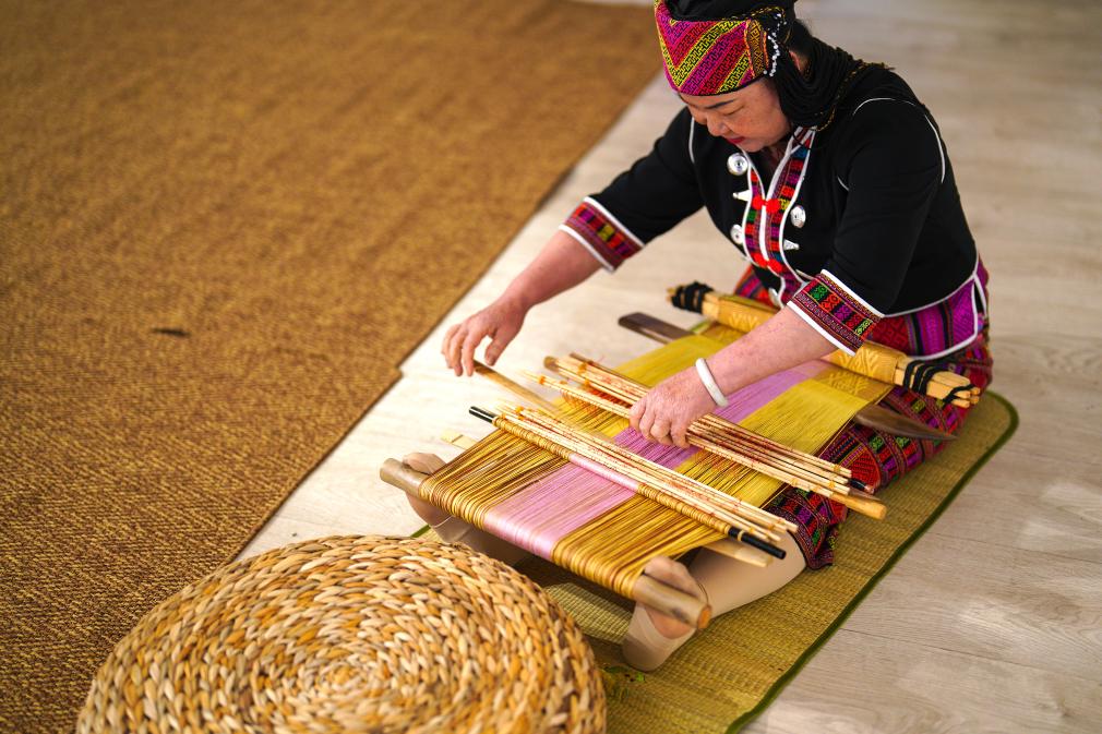 4月17日，黎族傳統(tǒng)紡染織繡技藝國家級代表性傳承人劉香蘭在2023年意大利米蘭設計周上展示黎錦織造技藝。新華社發(fā)