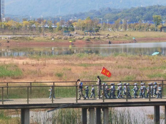 　　10月24日，秋游的幼兒園小朋友在老師帶領(lǐng)下走在清水塘公園里的木橋上。本報(bào)記者 常雯宜攝