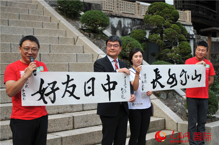 東京中國文化中心主任羅玉泉展示其為本次活動書寫的題詞“中日友好，山高水長”。人民網(wǎng) 蔣曉辰攝