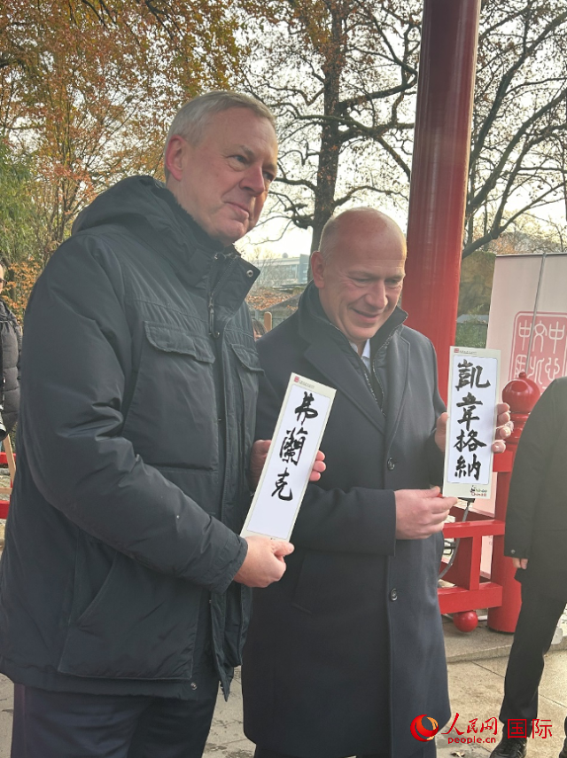 柏林市長韋格納（右）、動(dòng)物園監(jiān)事會(huì)主席布魯克曼（左）手持中國文化中心工作人員現(xiàn)場手書的中文名字。人民網(wǎng)記者 徐馨攝