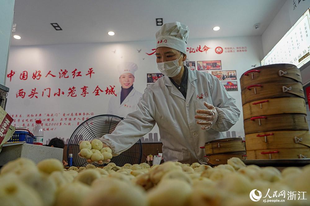 3月31日，在浙江省嵊州市甘霖鎮(zhèn)，嵊州小吃從業(yè)者沈紅平把蒸熟的小籠包晾涼，打包冷藏售賣。人民網(wǎng) 章勇濤攝