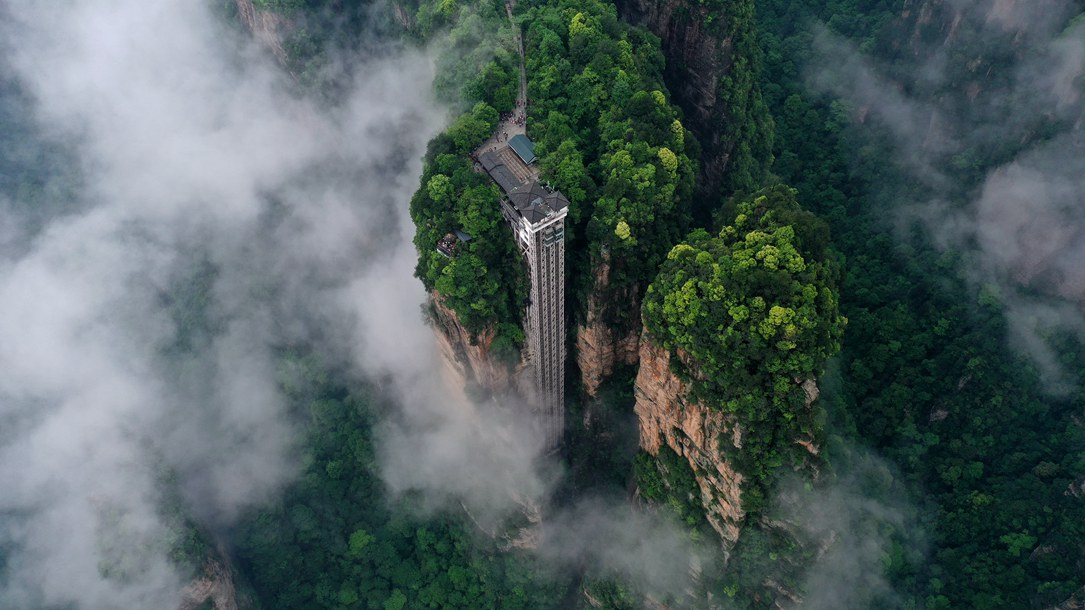 位于張家界武陵源景區(qū)的百龍?zhí)焯蓁偳对谠旗F繚繞的峰林間，雄偉壯觀。吳勇兵攝