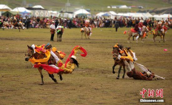 8月4日，四川理塘“八一”賽馬場上演一場精彩的馬術(shù)競技比賽，引來上萬民眾和游客觀賽。圖為牧民騎手進行五彩凌空競技。 中新社記者 劉忠俊 攝