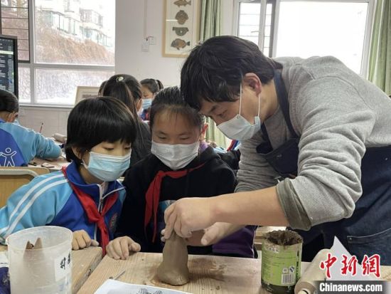 圖為西寧市勞動路小學(xué)教師賈煜與學(xué)生一起制作陶藝?！≈苋鸪阶?攝