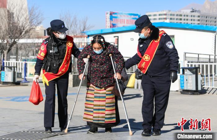 圖為拉薩鐵路公安民警幫助老人進(jìn)站乘車。　胡安鵬 攝