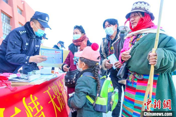 圖為拉薩鐵路公安民警向旅客發(fā)放乘車安全宣傳資料?！↑S飛 攝