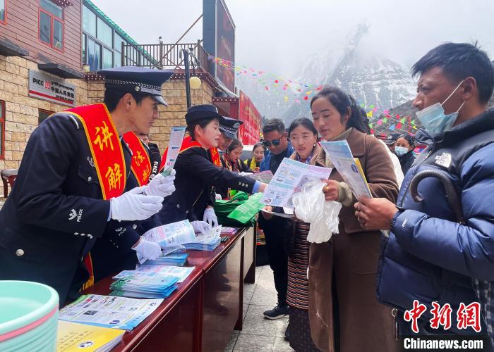 圖為山南玉麥邊境派出所民警為轄區(qū)群眾發(fā)放法律知識宣傳單?！＄婗?　攝