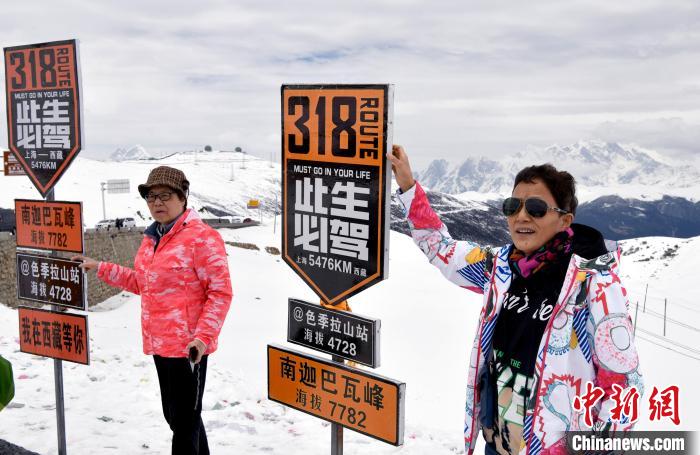 圖為5月14日，西藏林芝色季拉山觀景臺(tái)，游客與南迦巴瓦峰合影?！±盍?攝