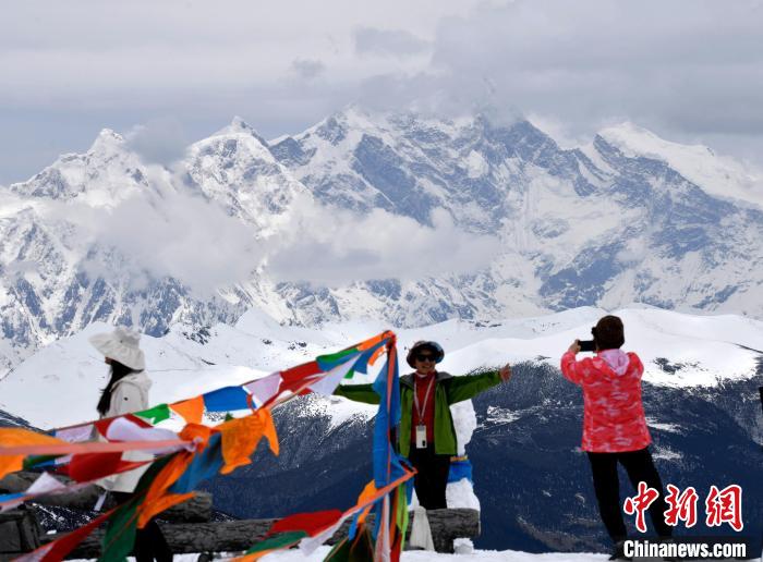 圖為5月14日，西藏林芝色季拉山觀景臺(tái)，游客與南迦巴瓦峰合影?！±盍?攝