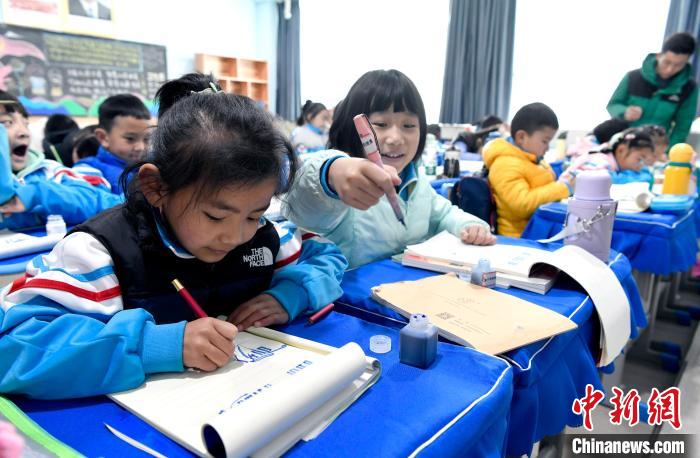 3月14日，西藏拉薩市第一小學(xué)一年級(jí)六班學(xué)生白瑪朗珍(圖左)在藏語(yǔ)文課上書寫藏文?！±盍?攝