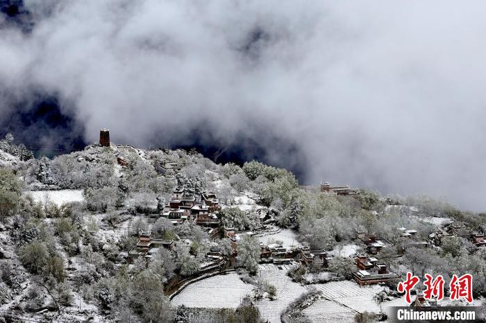 雪后的藏寨和碉樓構(gòu)成美麗的雪景?！〗党鯘衫?攝