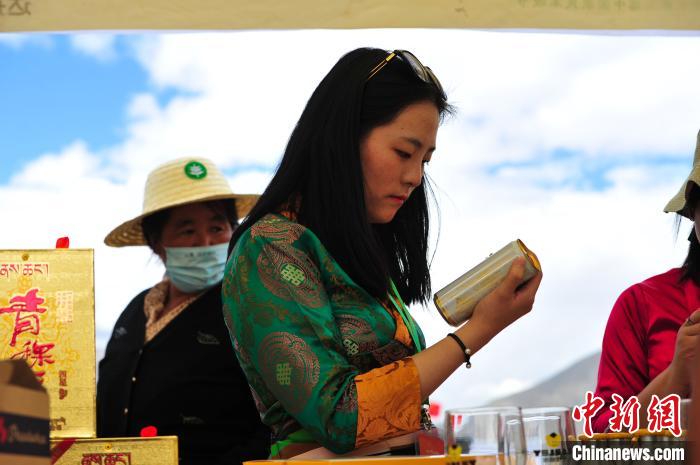 圖為拉薩市民在特色農(nóng)畜產(chǎn)品展示展銷會(huì)上選購(gòu)商品?！垈?攝