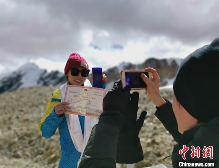 圖為5日，登頂洛堆峰的登山者獲得西藏自治區(qū)登山協(xié)會(huì)頒發(fā)的登頂證明?！垈?攝