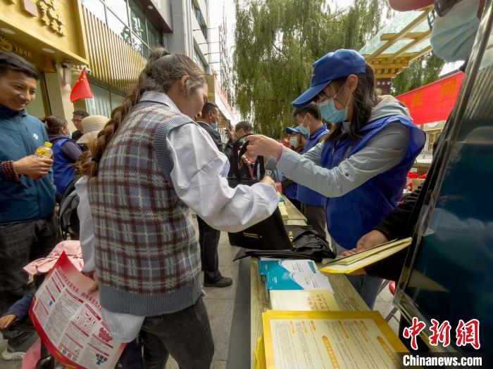 圖為志愿者為市民發(fā)放網(wǎng)絡(luò)安全宣傳手冊(cè)。　謝牧 攝