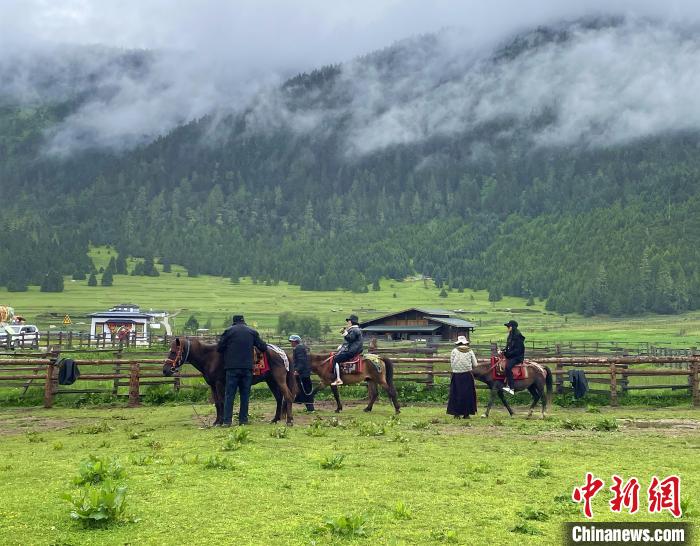 6月10日，游客在魯朗小鎮(zhèn)高山牧場景區(qū)體驗(yàn)騎馬。　冉文娟 攝