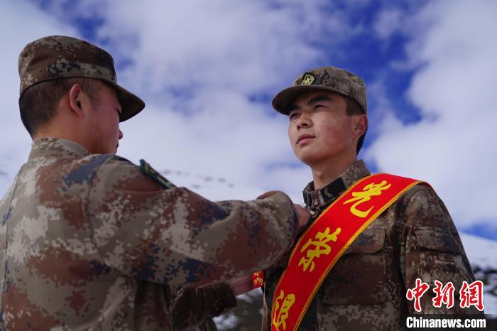 排長王朝偉(圖左)給退伍老兵佩戴大紅花?！∥鞑厣侥宪姺謪^(qū)某團(tuán)供圖