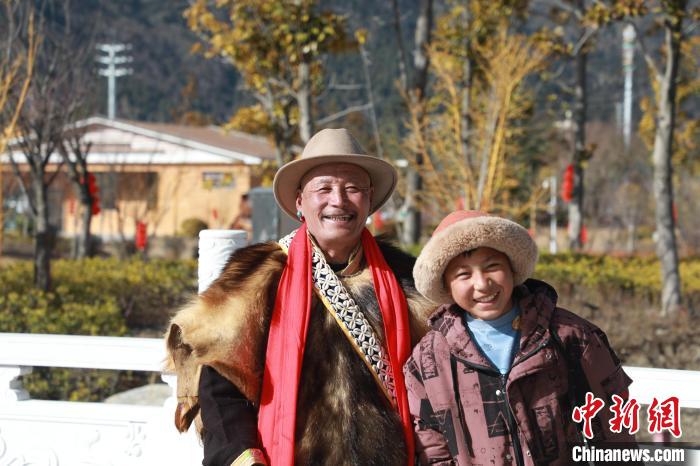 圖為林芝市巴宜區(qū)布久鄉(xiāng)仲果村村民桑杰與孫子一起參加藏歷新年活動(dòng)?！埩?攝