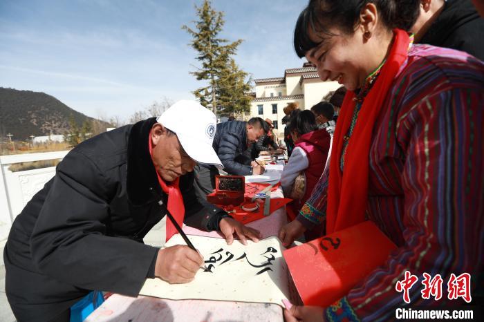 圖為林芝市文聯(lián)書(shū)法家協(xié)會(huì)會(huì)員向民眾贈(zèng)送藏文書(shū)法作品?！埩?攝