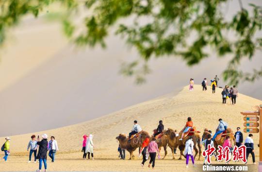 甘肅敦煌開啟旅游旺季數(shù)萬人“五一”暢游鳴沙山